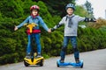Happy boys riding on hoverboards or gyroscooters outdoor