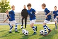 Happy boys on a sports training class with young coach. School age children making sport.