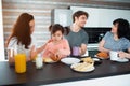 Happy breakfast of a large family in the kitchen. Siblings, parents and children, mother and grandmother. Father and Royalty Free Stock Photo