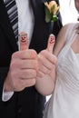 Happy bridal pair with thumbs up. Lucky couple get married.