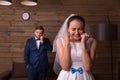 Happy bride against groom talking on the phone Royalty Free Stock Photo