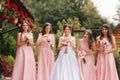 Happy bride with bridesmaid hold bouquets and have fun outside. Beautiful bridesmaid in same dresses stand by the Royalty Free Stock Photo