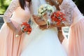 happy bride and bridesmaids showing their luxury bouquets at gorgeous wedding reception