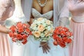 happy bride and bridesmaids showing their luxury bouquets at gorgeous wedding reception