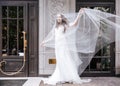 Happy bride covered with flying veil standing on street Royalty Free Stock Photo