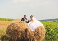 Happy bride and grom on the heap of hay
