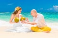 Happy bride and groom drink coconut water and having fun on a tr Royalty Free Stock Photo