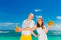 Happy bride and groom drink coconut water on a tropical beach. W Royalty Free Stock Photo