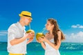 Happy bride and groom drink coconut water on a tropical beach. W Royalty Free Stock Photo