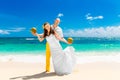 Happy bride and groom drink coconut water on a tropical beach. W Royalty Free Stock Photo