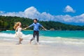 Happy bride and groom having fun on a tropical beach Royalty Free Stock Photo