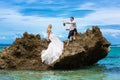 Happy bride and groom having fun on a tropical beach under the p Royalty Free Stock Photo