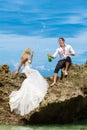 Happy bride and groom having fun on a tropical beach under the p Royalty Free Stock Photo