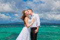 Happy bride and groom having fun on a tropical beach under the p Royalty Free Stock Photo