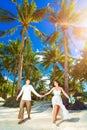 Happy bride and groom having fun on a tropical beach under the p Royalty Free Stock Photo