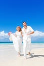 Happy bride and groom having fun on a tropical beach. Wedding an Royalty Free Stock Photo