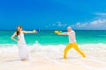 Happy bride and groom having fun in the waves on a tropical beach. Wedding and honeymoon on the tropical island. Royalty Free Stock Photo