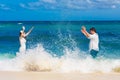 Happy bride and groom having fun in the waves on a tropical beach Royalty Free Stock Photo