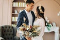 Happy bride and groom holding a bouquet of wedding flowers, Happy young couple, Bride and groom posing and looking at each other Royalty Free Stock Photo