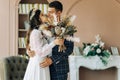 Happy bride and groom holding a bouquet of wedding flowers, Happy young couple, Bride and groom posing and looking at each other Royalty Free Stock Photo