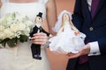 Happy bride and groom holding cute handmade dolls of husband and