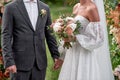 Happy bride and groom holding hands on wedding ceremony, copy space. Wedding couple in love, newlyweds. Bridal bouquet. Royalty Free Stock Photo