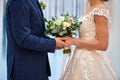 Happy bride and groom holding hands on wedding ceremony, copy space. Wedding couple in love, newlyweds. Bridal bouquet Royalty Free Stock Photo