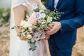 Happy bride and groom hugging with a bouquet in their hands Royalty Free Stock Photo