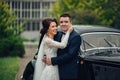 stylish bride and groom sensually posing near retro car with boh Royalty Free Stock Photo