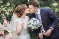 Happy bride and groom kissing and holding champagne glasses. happy group of people toasting with champagne. hands holding glasses Royalty Free Stock Photo