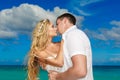 Happy bride and groom kissing on a tropical beach. Blue sea in t Royalty Free Stock Photo