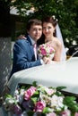 Happy bride and groom near wedding limo Royalty Free Stock Photo