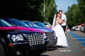 Happy bride and groom near wedding limousines Royalty Free Stock Photo