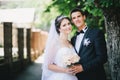 Happy bride and groom posing in a park