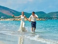 Happy Bride and groom running on a beautiful tropical beach Royalty Free Stock Photo