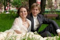 Happy bride and groom sitting together on the gras Royalty Free Stock Photo