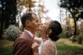 happy bride, groom standing in green park, kissing, smiling, laughing. lovers in wedding day. happy young couple in love Royalty Free Stock Photo