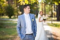 Happy bride, groom standing in green park, kissing, smiling, laughing. lovers in wedding day. happy young couple in love. Royalty Free Stock Photo