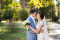 Happy bride, groom standing in green park, kissing, smiling, laughing. lovers in wedding day. happy young couple in love. Royalty Free Stock Photo