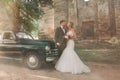 Happy bride and groom standing near vintage car Royalty Free Stock Photo