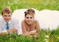 Happy bride and groom lay on the green grass. Wedding day Royalty Free Stock Photo