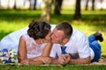Happy bride and groom on their wedding lies on the grass in park and kiss Royalty Free Stock Photo