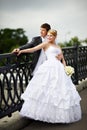Happy bride and groom at wedding walk on bridge