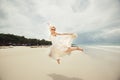 Happy bride jumping in wedding dress at the sea. young happy woman on beach.