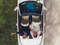 Happy bride kiss groom, newlywed wedding couple is driving a convertible retro car with balloons on a country road for Royalty Free Stock Photo