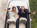 Happy bride kiss groom, newlywed wedding couple is driving a convertible retro car with balloons on a country road for Royalty Free Stock Photo