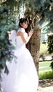 Happy Bride smiling near summer tree outdoors