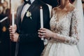 Happy bride and stylish groom holding candles with light during wedding ceremony. wedding couple at matrimony in church. emotional Royalty Free Stock Photo