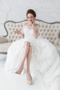 Happy bride talking over cell phone sitting on classic luxury sofa Royalty Free Stock Photo