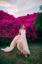 Happy bride walks among blooming trees and flowers during the honeymoon Royalty Free Stock Photo